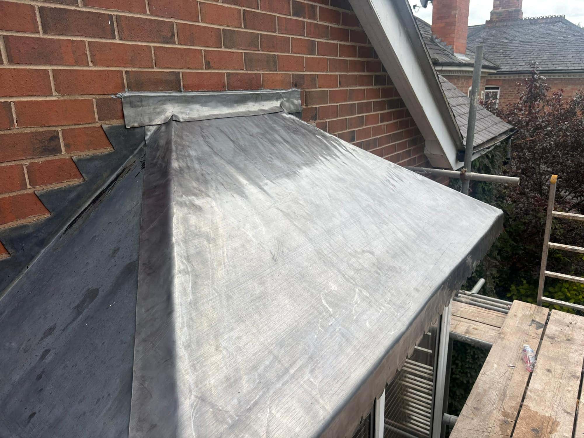 Side view of a bay roof in Beverley replaced in Code 6 lead, with lead flashing to the brickwork above — Armour Shield Roofing Services