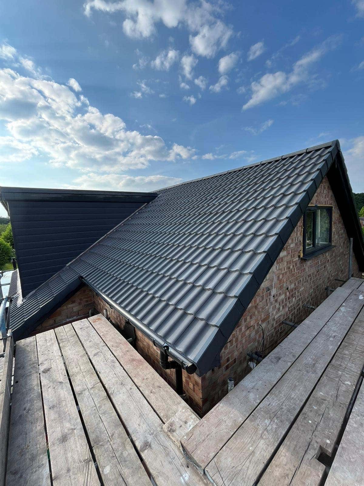 New charcoal double pantile roof in Beverley with anthracite cladding and fascia, viewed along the scaffold — Armour Shield Roofing Services