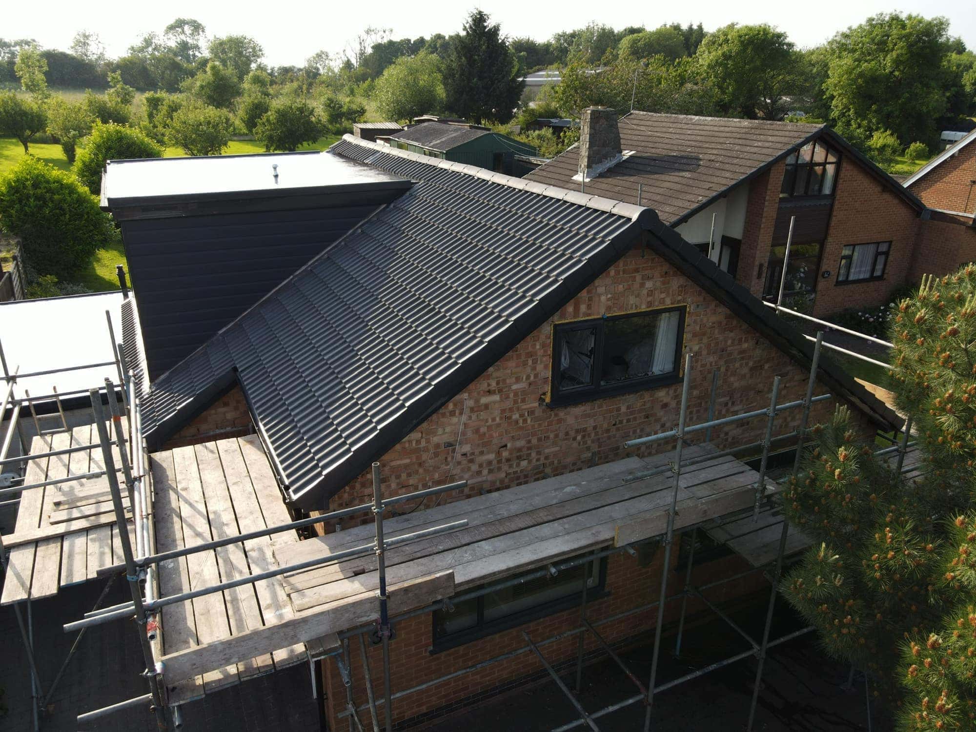 Drone view of a completed re-roof in Beverley in charcoal double pantiles, with an anthracite-clad dormer and liquid-applied flat roof — Armour Shield Roofing Services
